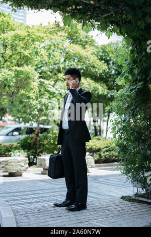 Young businessman talking on the phone in the city Stock Photo