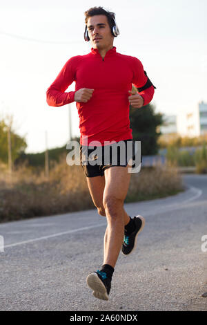 Jogger with smartphone in arm pocket and headphones Stock Photo