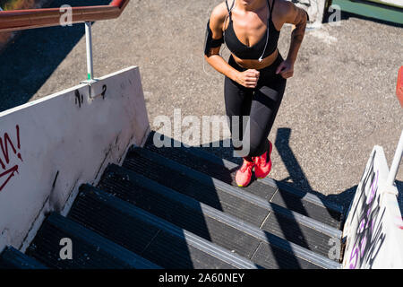 Young woman running upstairs Stock Photo