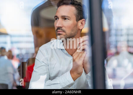 Portrait of businessman behind windowpane in a cafe Stock Photo