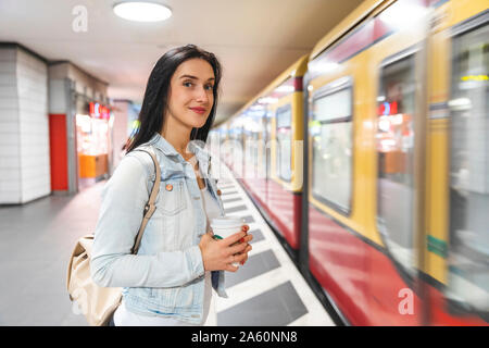 Young woman at metro station waiting for the train, Berlin, Germany Stock Photo