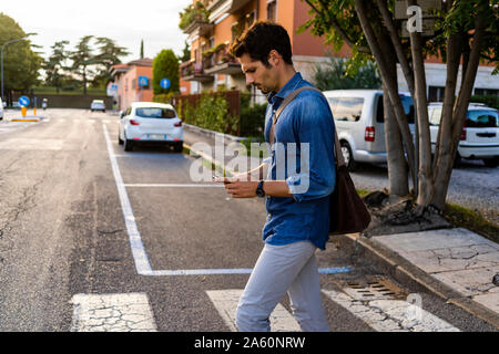 Man crossing street in the city Stock Photo