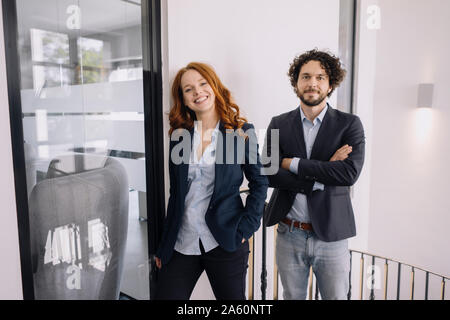Portrait of confident businessman and businesswoman in office Stock Photo