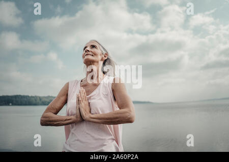 Senior woman meditation at the sea Stock Photo