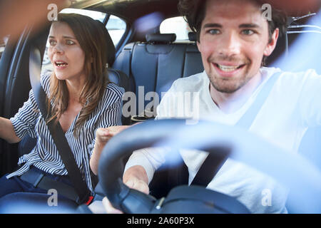 Shocked couple in a car with man driving