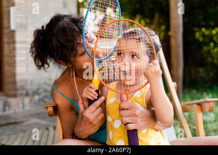 Grandmother playing with little girl and badminton rackets outdoors Stock Photo