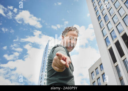 Portrait of mature man in the city screaming and pointing his finger Stock Photo