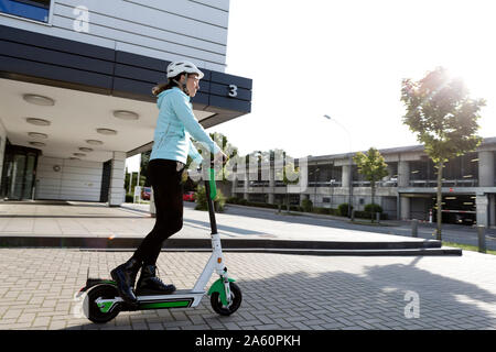 Mature woman riding electric scooter in the city Stock Photo