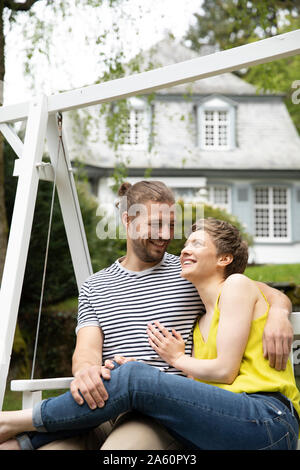 Happy relaxed couple in garden of their home Stock Photo