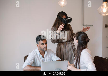 Colleagues working in office testing VR simulator Stock Photo