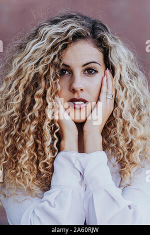 Portrait of young woman with dyed blond ringlets Stock Photo