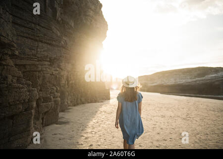 Woman walking on Cathedrals Beach with rocks, rear view, Galicia, Spain Stock Photo