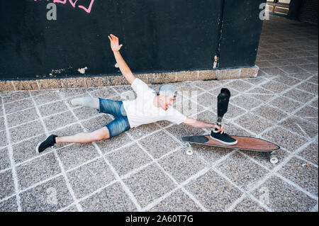 Amputated young man having fun with leg prosthesis and skateboard Stock Photo