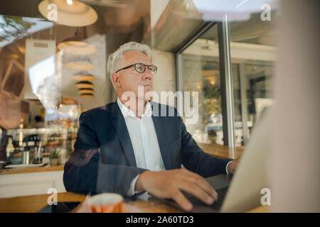 Senior businessman using laptop in a cafe Stock Photo