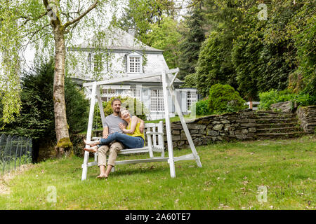 Relaxed couple in garden of their home Stock Photo