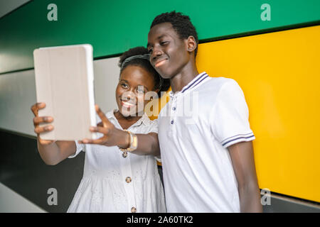 Portrait of happy young young couple taking selfie with digital tablet Stock Photo