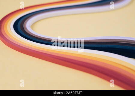 Multi colored quilling papers on beige background Stock Photo