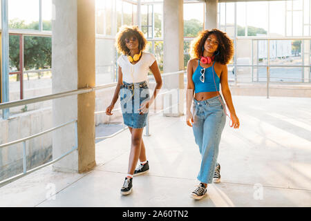 Portrait of two young women with headphones in the evening Stock Photo