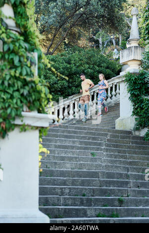 Man and woman running down stairs Stock Photo
