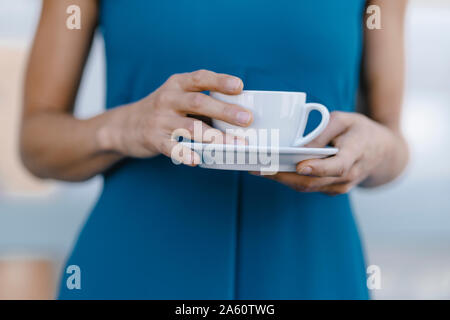 Businesswoman holding cup of coffee, mid section Stock Photo