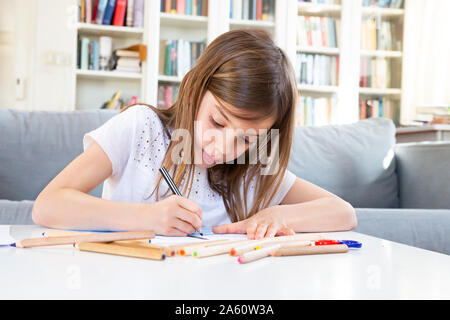 Portrait of girl drawing with coloured pencil at home Stock Photo