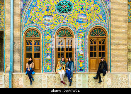 Group of young Iranian women seated in front of ceramic tiles, Golestan Palace, UNESCO, Tehran, Islamic Republic of Iran, Middle East Stock Photo