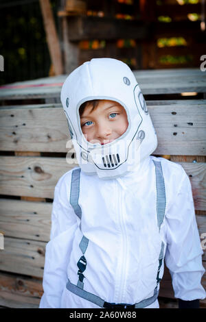 Young boy as a superhero, astronaut playing in a tree house Stock Photo