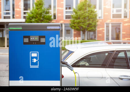 Electric car gettig charged at an charging station Stock Photo