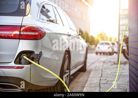 Electric car gettig charged at an charging station Stock Photo