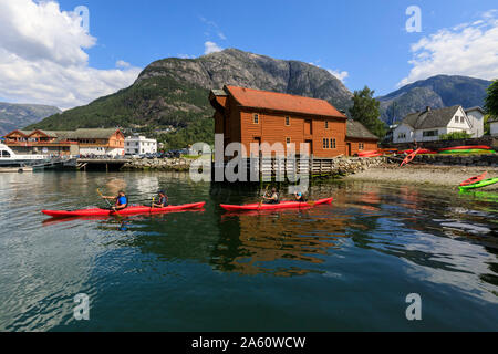 Sea kayakers head off, beautiful Eidfjord village, mountains and beach, sunny day, Norwegian Western Fjords, Norway, Scandinavia, Europe Stock Photo