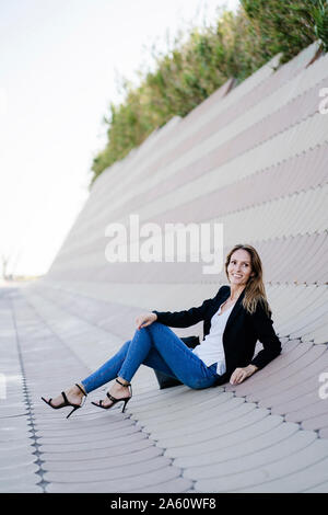 Businesswoman relaxing outdoors sitting on slabs Stock Photo