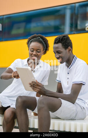 Young couple using digital tablet outdoors Stock Photo