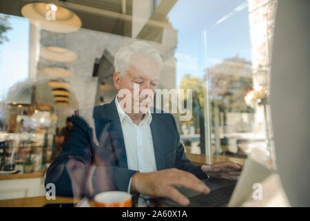 Senior businessman using laptop in a cafe Stock Photo