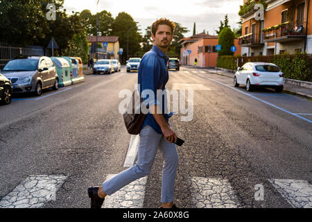 Man crossing street in the city Stock Photo