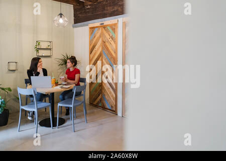 Two young women with laptop in a cafe Stock Photo