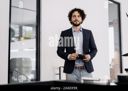 Businessman having a coffee break in office Stock Photo