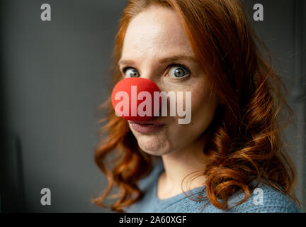 Portrait of redheaded woman with clown's nose Stock Photo