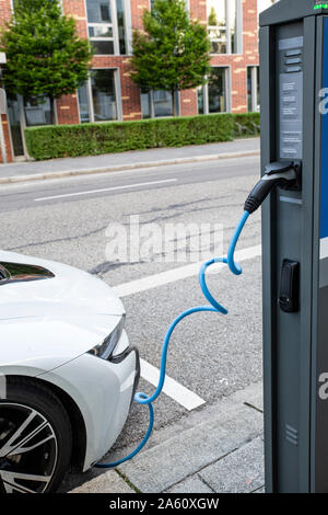 Electric car gettig charged at an charging station Stock Photo