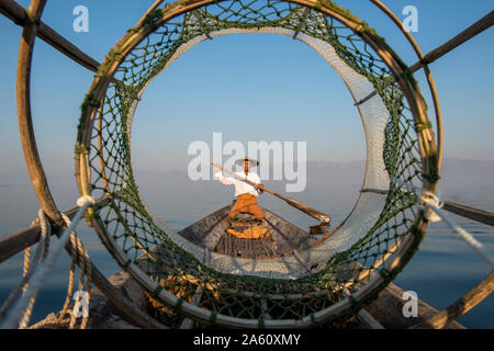 Intha leg rowing fisherman looking through fishing net, Inle Lake, Shan State, Myanmar (Burma), Asia Stock Photo