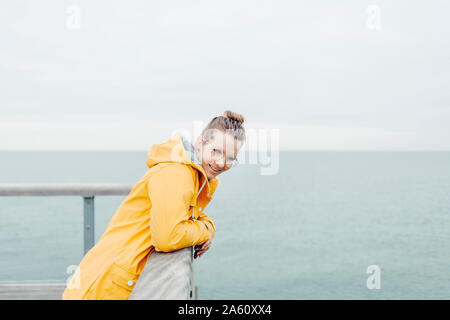 Young woman wearing yellow rain coat Stock Photo
