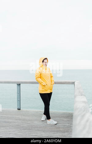 Young woman wearing yellow rain coat Stock Photo