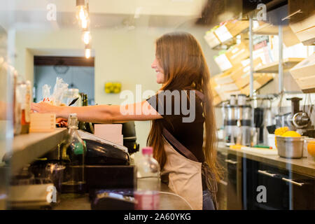 Young woman working at the counter in a cafe Stock Photo