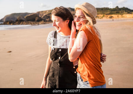 Two girlfriends having fun, walking on the beach Stock Photo