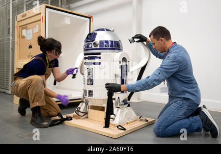 Museum technician Jessie Giovane Staniland and curator Patrick Luetzelschwab take the original R2-D2, used in the 1977 Star Wars film, out of its crate as it arrives at V&A Dundee where it will be the centrepiece of the forthcoming Hello, Robot exhibition. Stock Photo