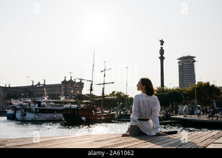 Pretty businesswoman sitting at the marina after work, relaxing Stock Photo