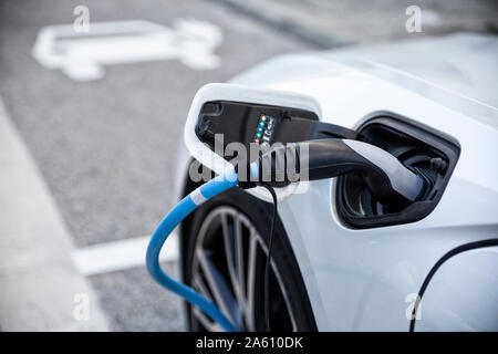 Electric car gettig charged at an charging station Stock Photo