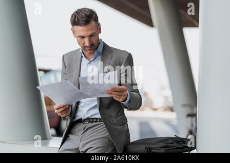 Businessman reviewing papers outdoors Stock Photo