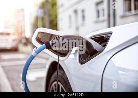 Electric car gettig charged at an charging station Stock Photo