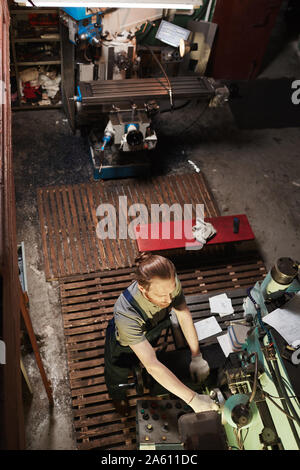 High angle view of mechanic working on lathe with tools in the warehouse Stock Photo