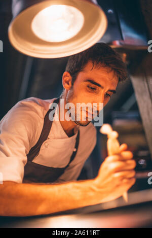 Chef using a pastry bag in the kitchen of a restaurant Stock Photo